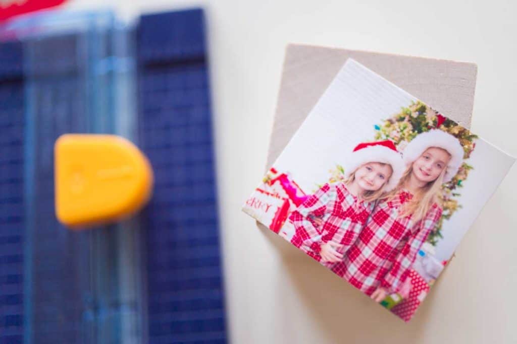 A photo trimmer next to a trimmed photo and wooden block.