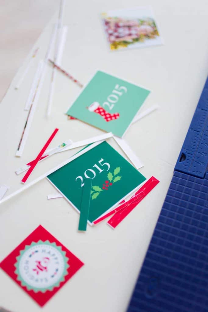 Trimmed decorative squares on a table next to a paper trimmer.