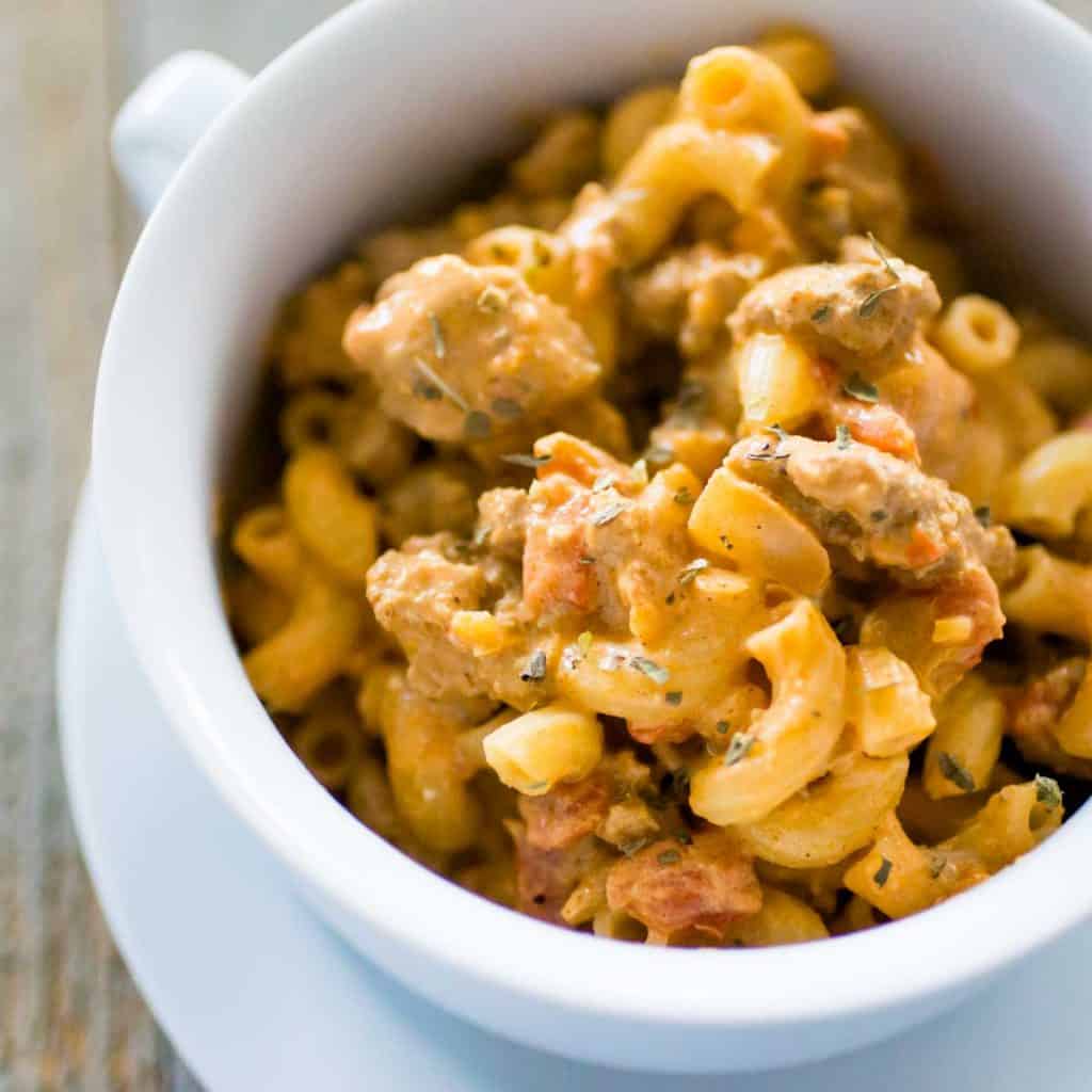 A bowl of elbow noodles coated in a creamy taco mac sauce with ground turkey.