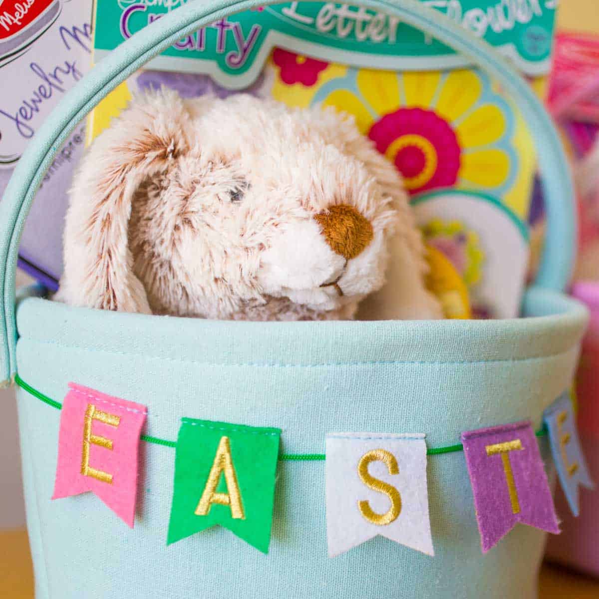 A stuffed bunny toy sits inside a light blue Easter basket.