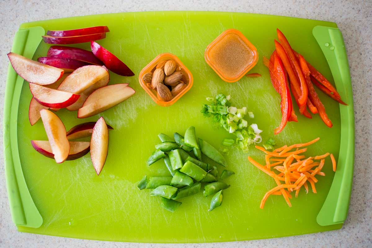 The Asian salad toppings have been sliced on a cutting board.
