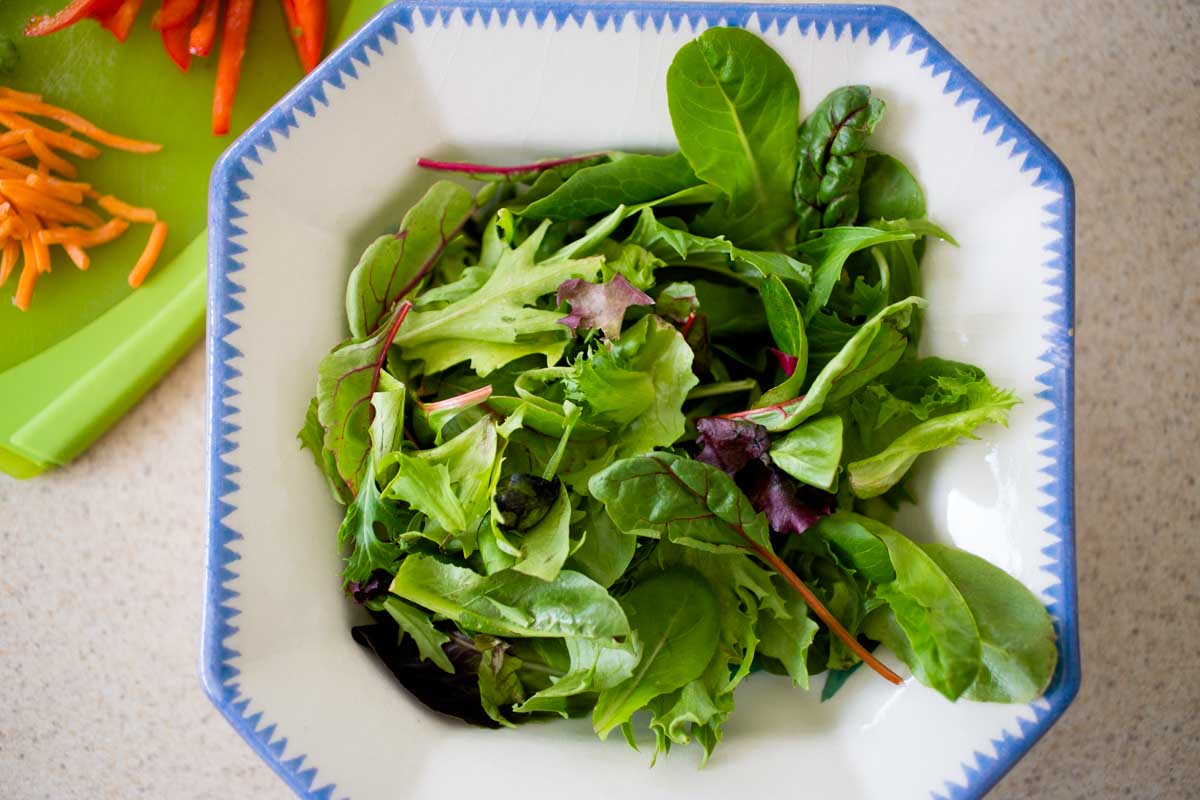 A salad bowl is filled with mixed greens.