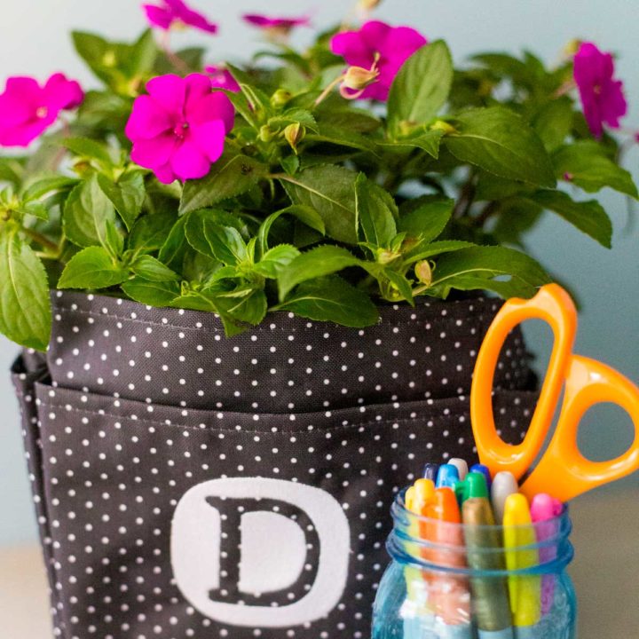 A canvas tote bag with a blooming plant inside.