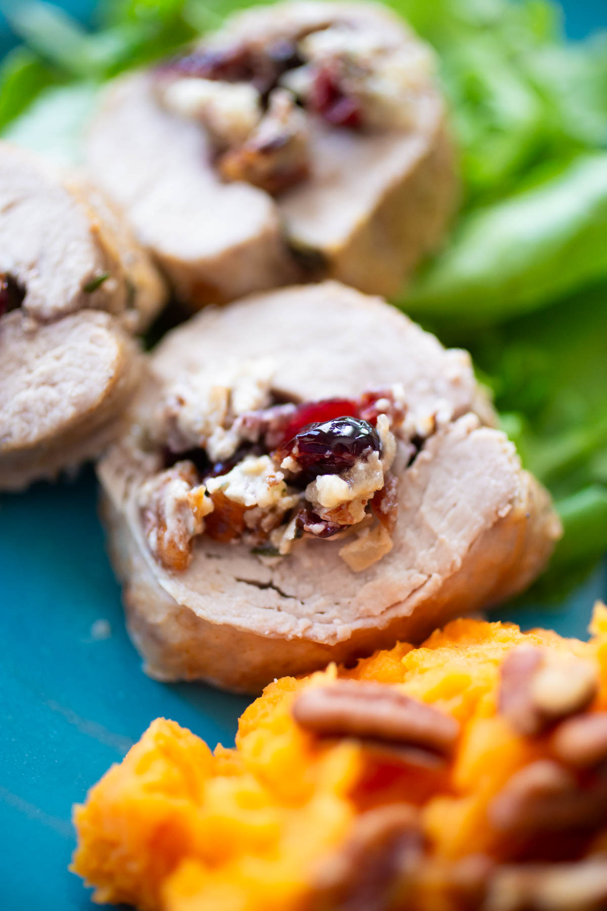 The pork tenderloin has been sliced and served, you can see the cranberry blue cheese filling.