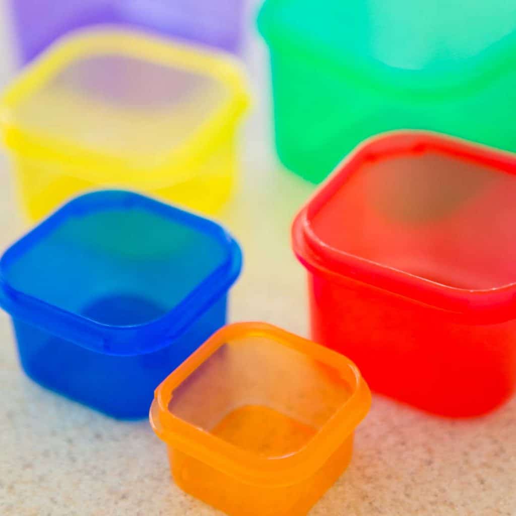 Rainbow colored portion cups for the 21 Day Fix are displayed on a counter.