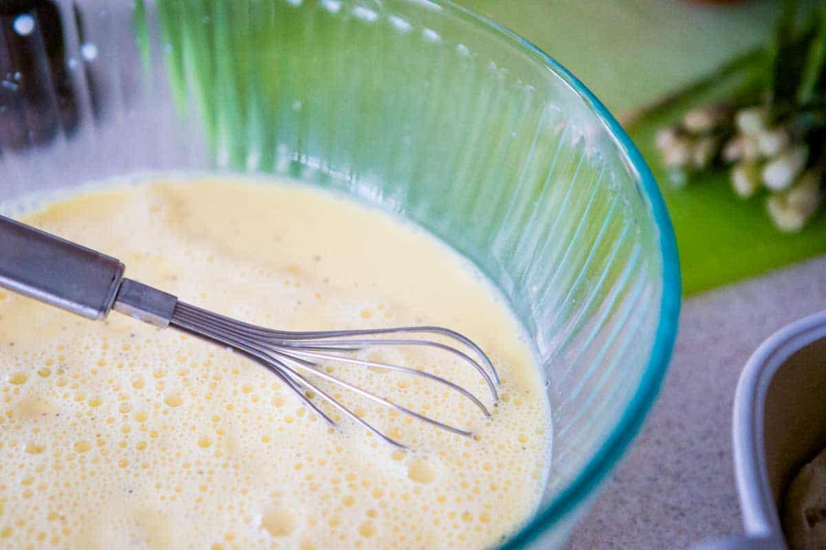 The eggs have been whisked in a large mixing bowl.