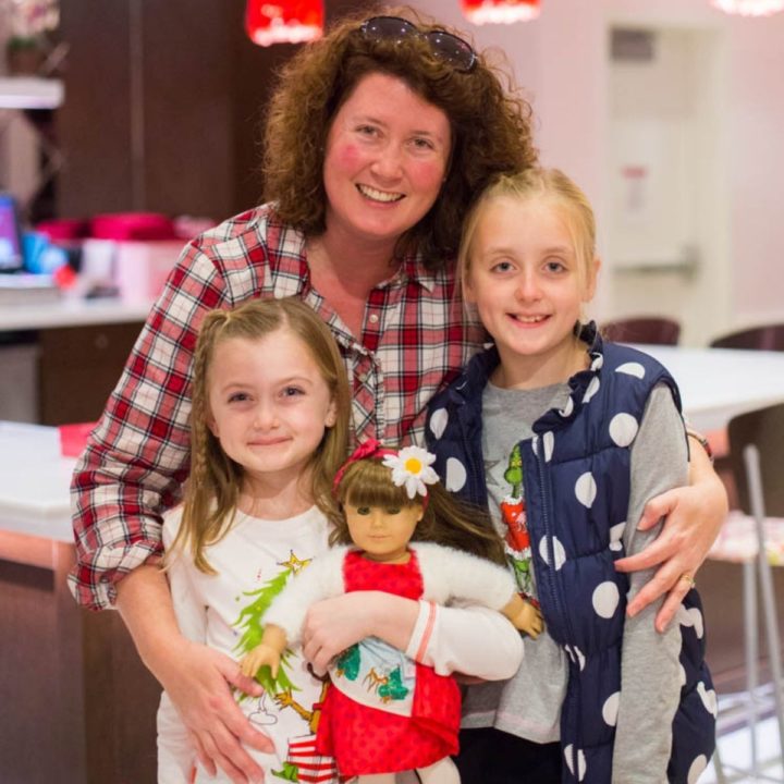 A mom poses with her two daughters during a Christmas Girls Day Out.