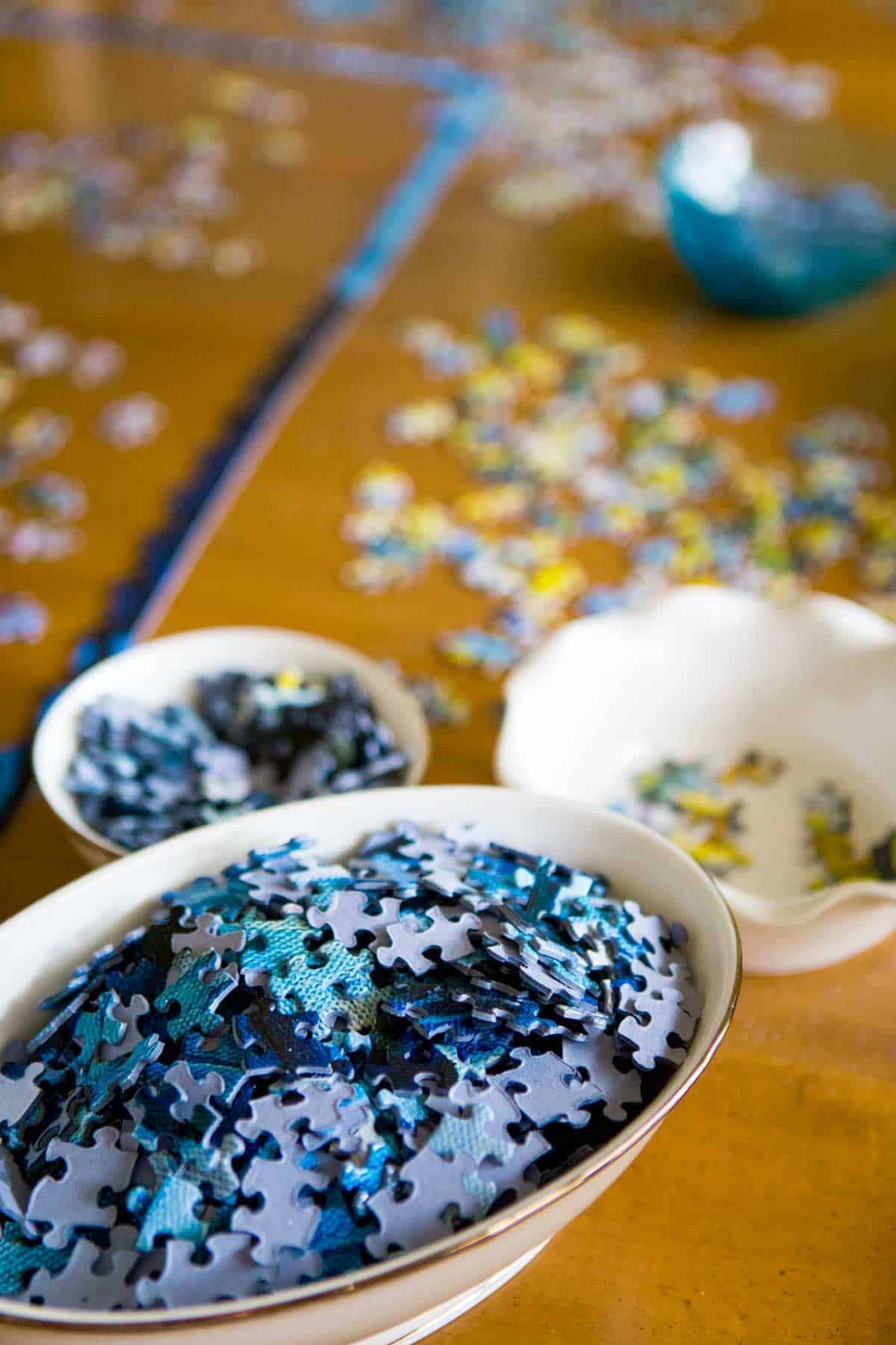 Dishware holding sorted pieces of puzzles.