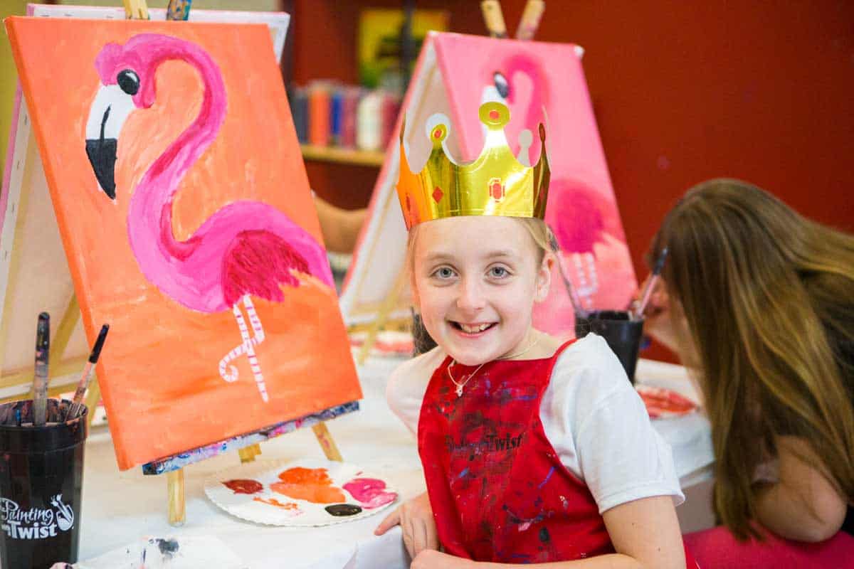 A birthday girl paints a flamingo at a party.