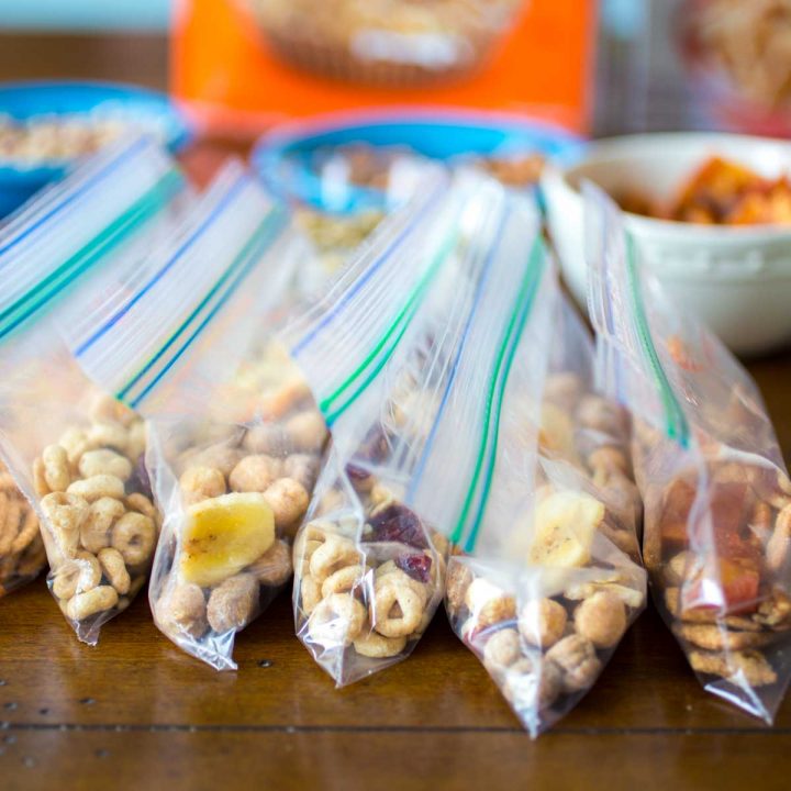 Several snack bags of homemade trail mix are lined up before a road trip.