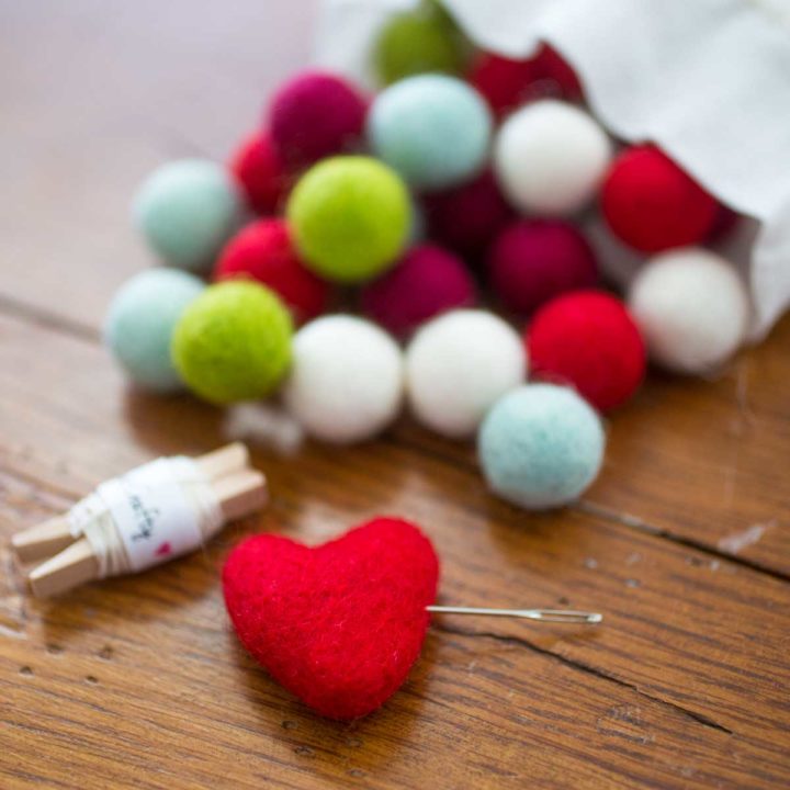 Colorful felt balls are spilling out of a muslin bag.