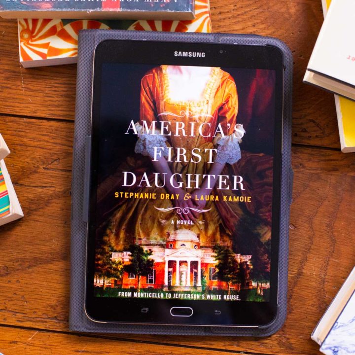A copy of America's First Daughter appears on a digital reader tablet screen on a table.