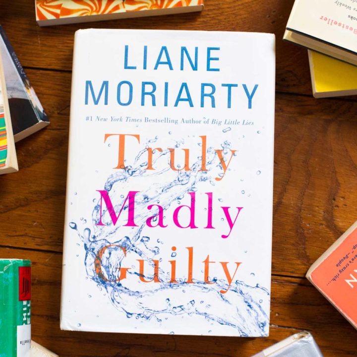 A copy of Truly Madly Guilty by Liane Moriarty sits on a table.