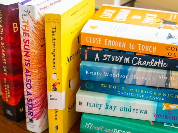 A stack of books from the 2018 book club sit on a table.