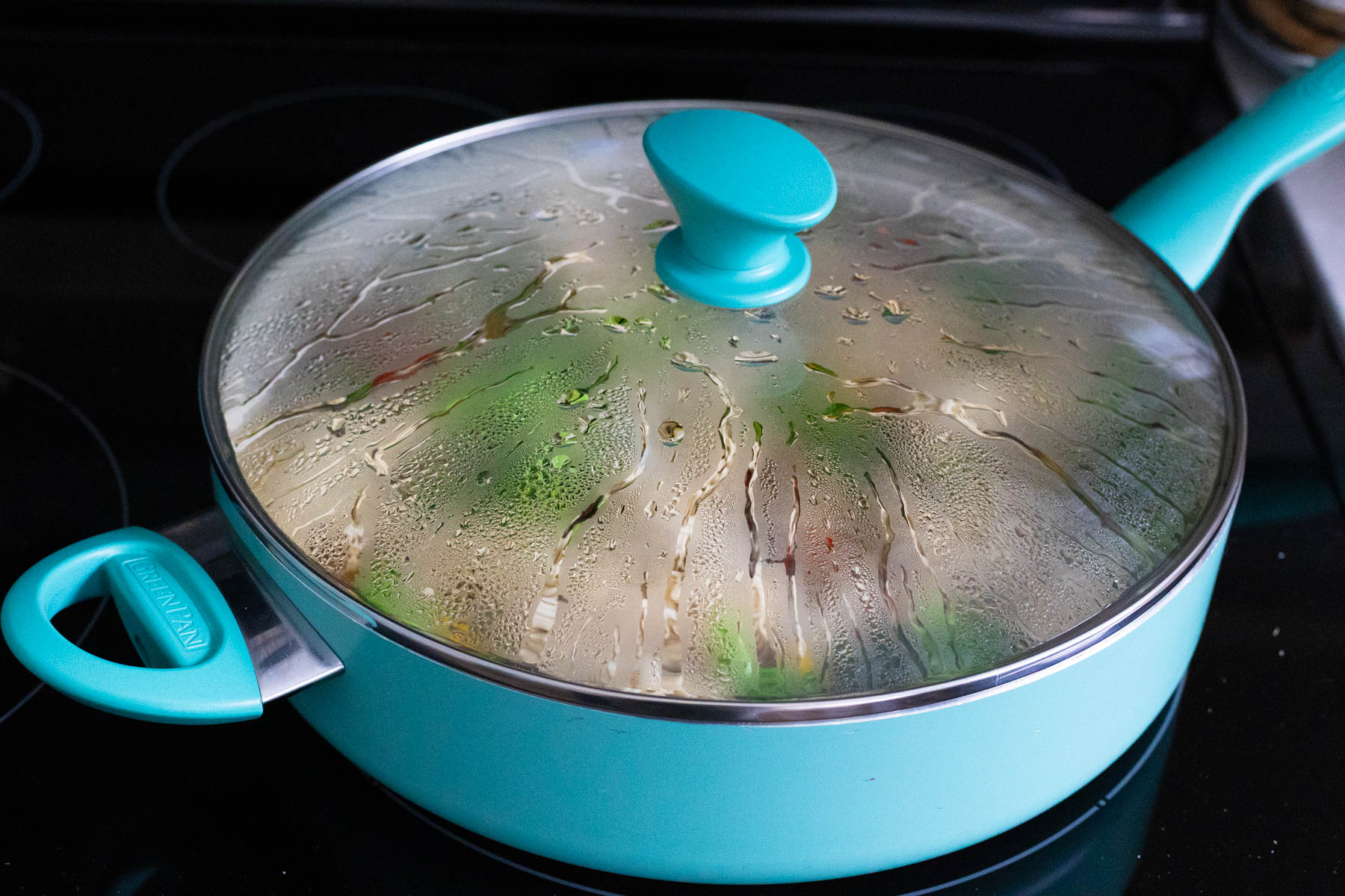The saute pan has been covered with a lid for the noodles to cook.