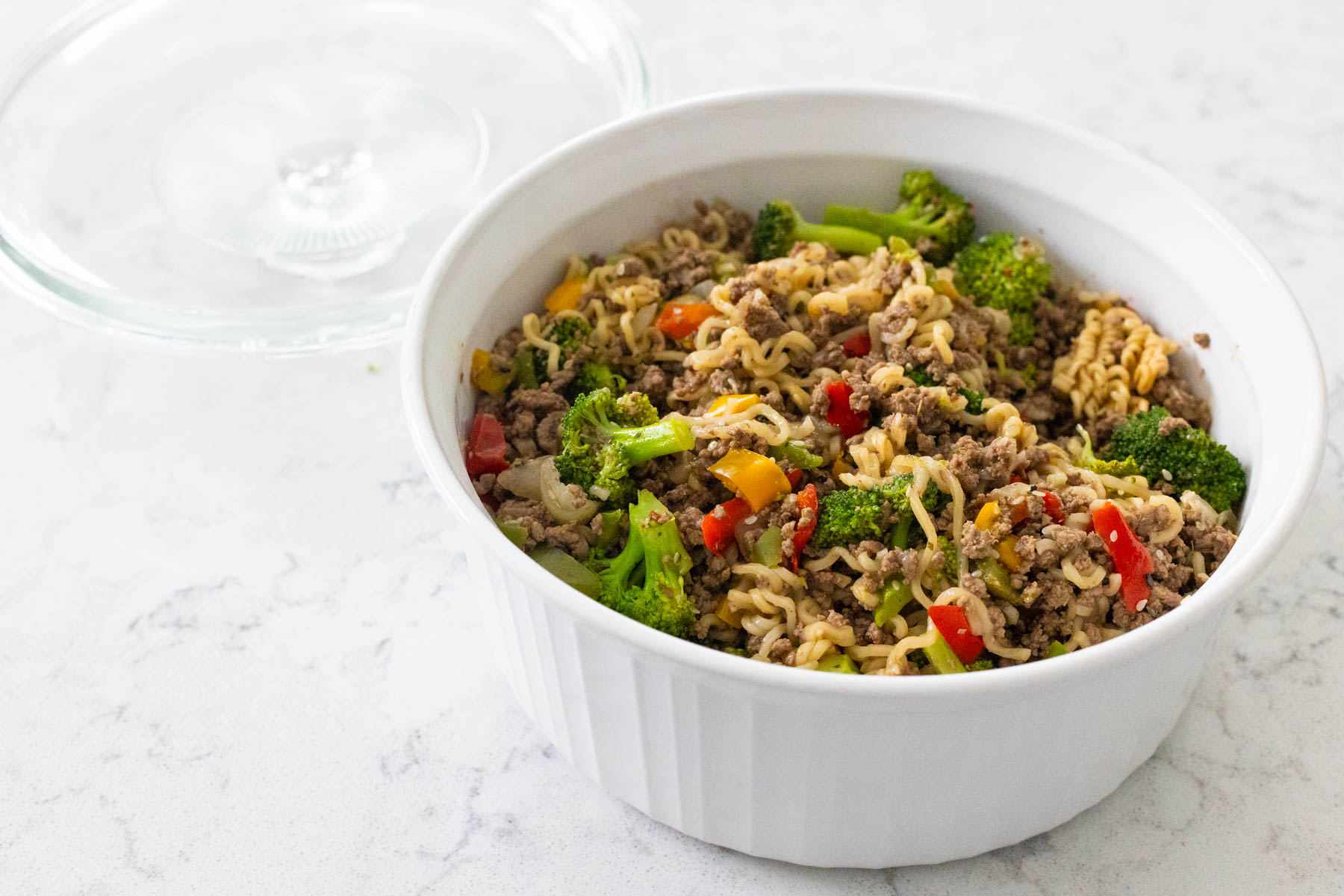 The white storage dish has the prepared ground beef stir fry ready to go in the fridge.