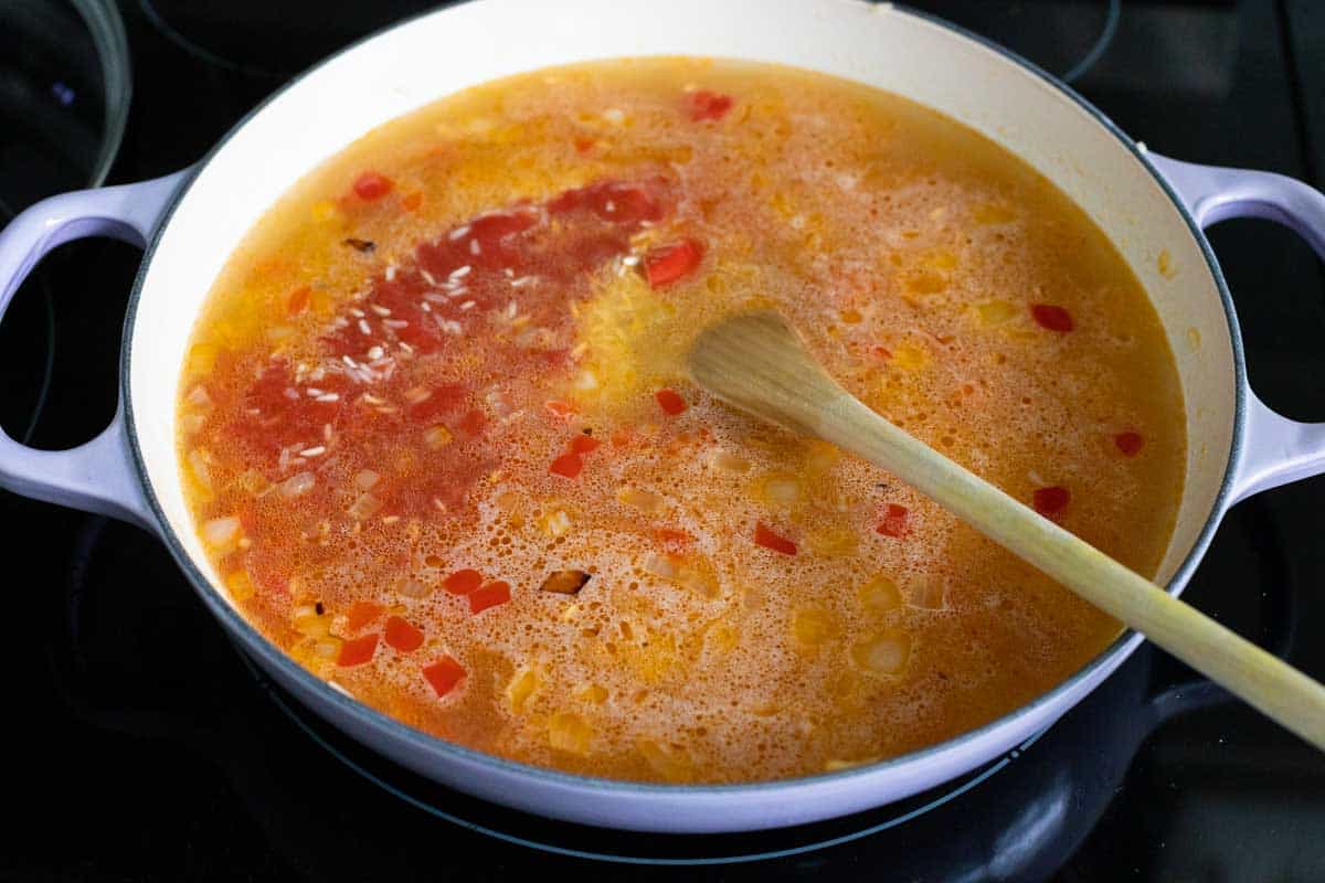 The tomato sauce and chicken stock are added to the skillet.