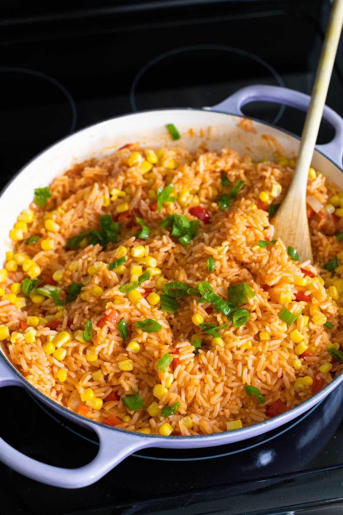 The skillet has the finished Mexican rice sprinkled with fresh green onions.