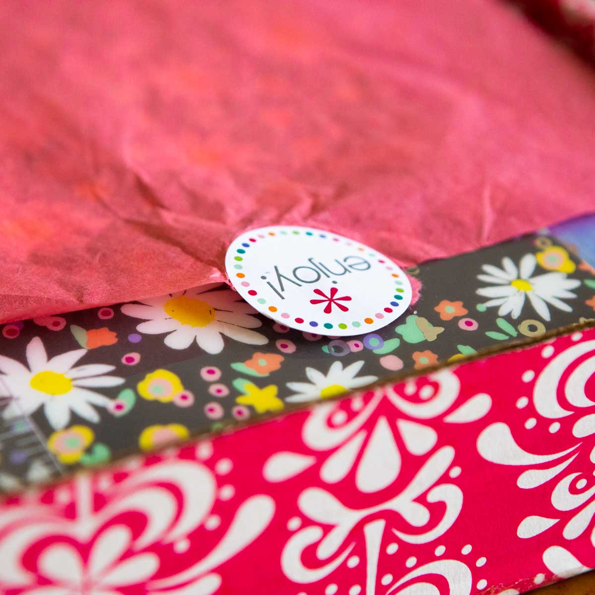 An Erin Condren life planner sits in the red and white gift box it arrived in wrapped in tissue paper.