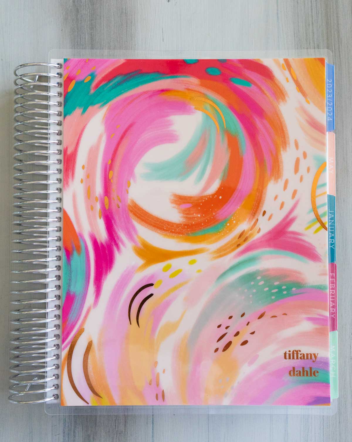 The front of the Erin Condren planner has colorful pink, orange, and teal swirls.