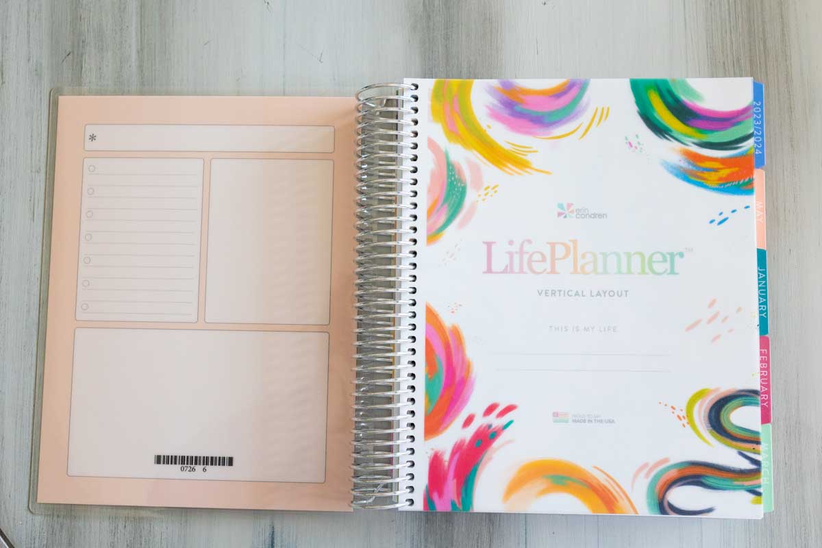 The Erin Condren planner is open to show the laminated cover for note taking.