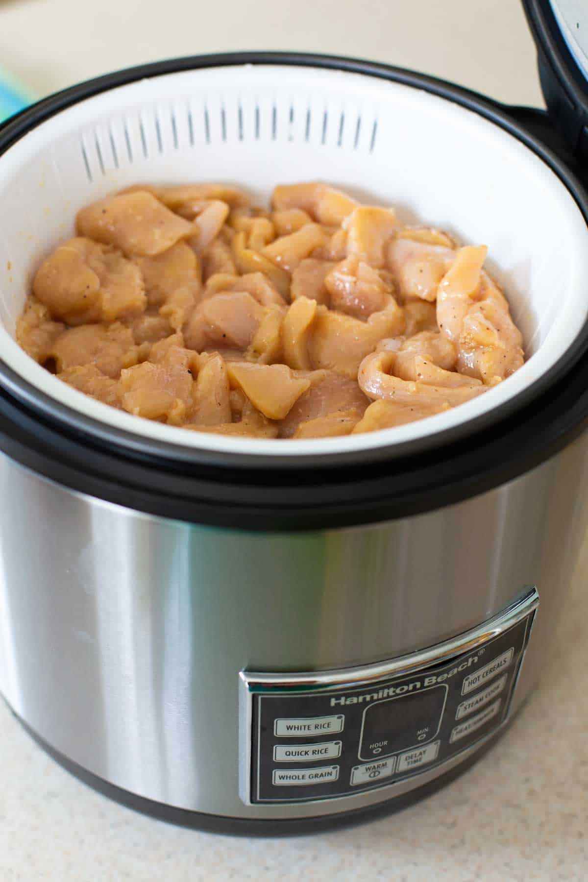 The marinated chicken pieces are in the Instant Pot steamer basket.