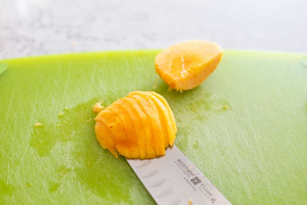 A fresh peach has been sliced for baking.