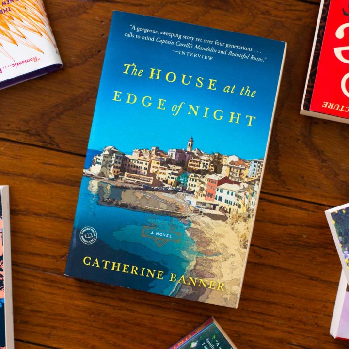 A copy of The House at the Edge of Night sits on a table.