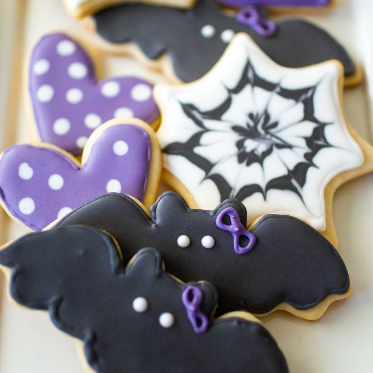 Sugar cookie platter with black bat sugar cookies with purple polka dot hearts and spider web shapes.