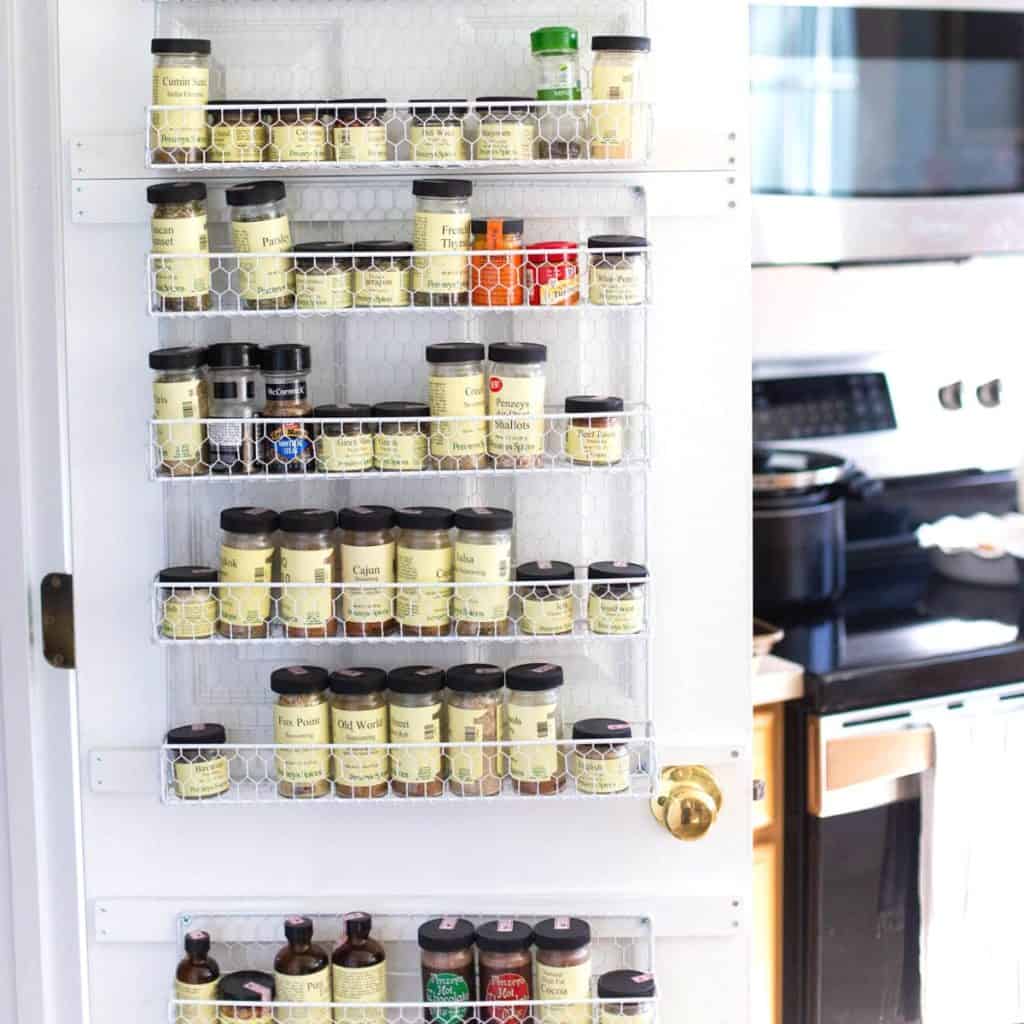 A spice rack hangs on the pantry door.