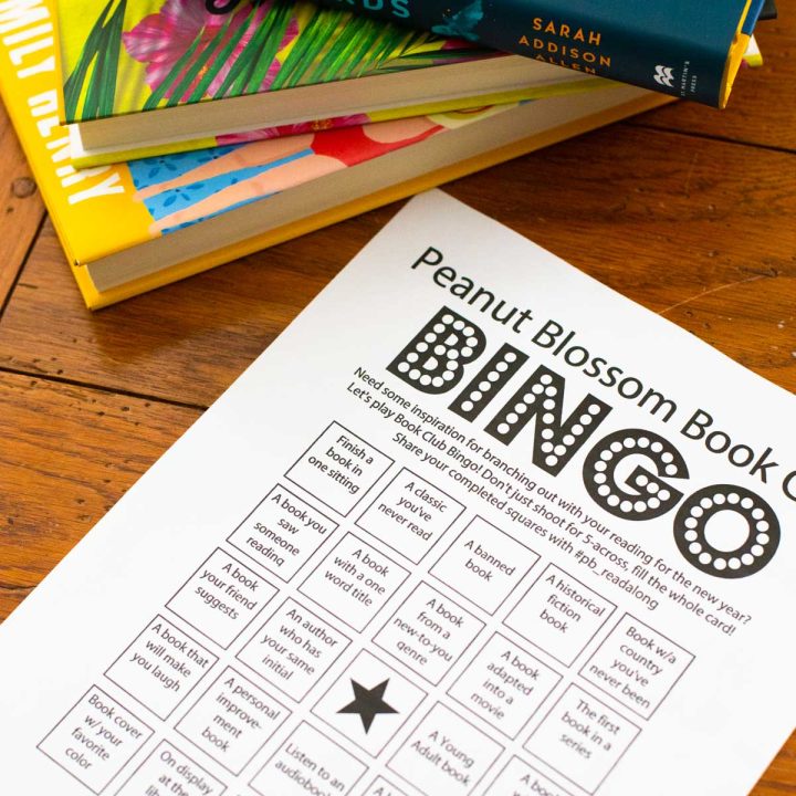 A bingo card next to a stack of books.