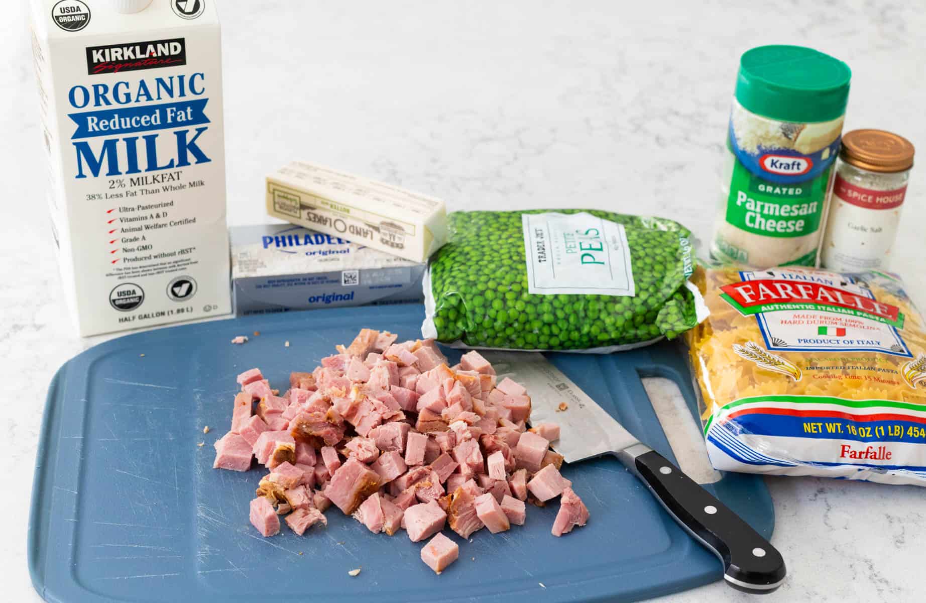 The ingredients to make the ham alfredo dish are on the counter.