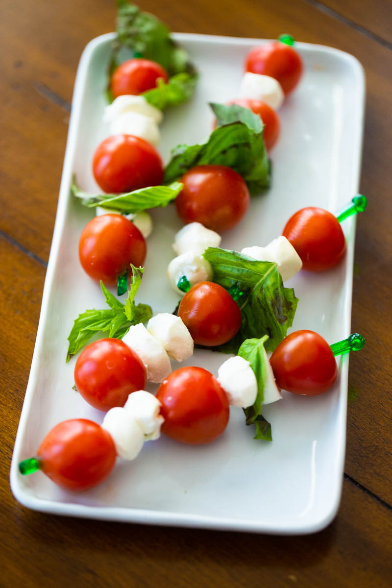 Kabobs of tomato caprese bites are on a platter.