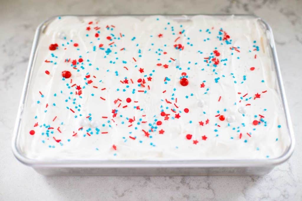 Step 4: The top of the cake has been frosted with Cool Whip and sprinkles.