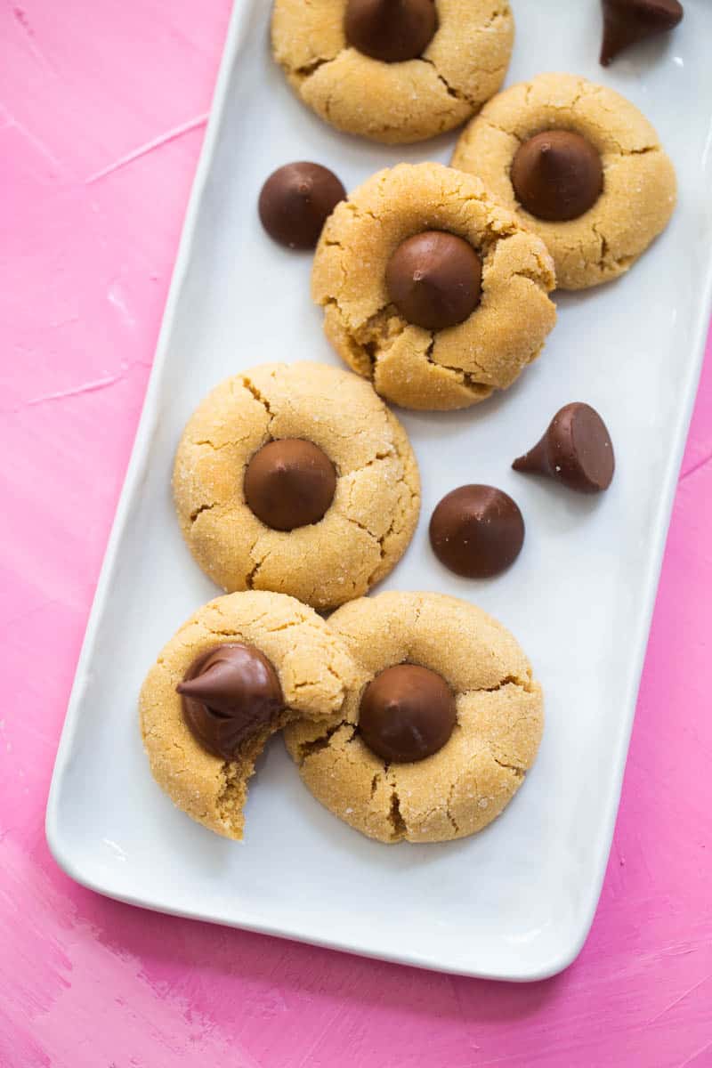 The finished peanut butter blossom cookies are on a white platter.