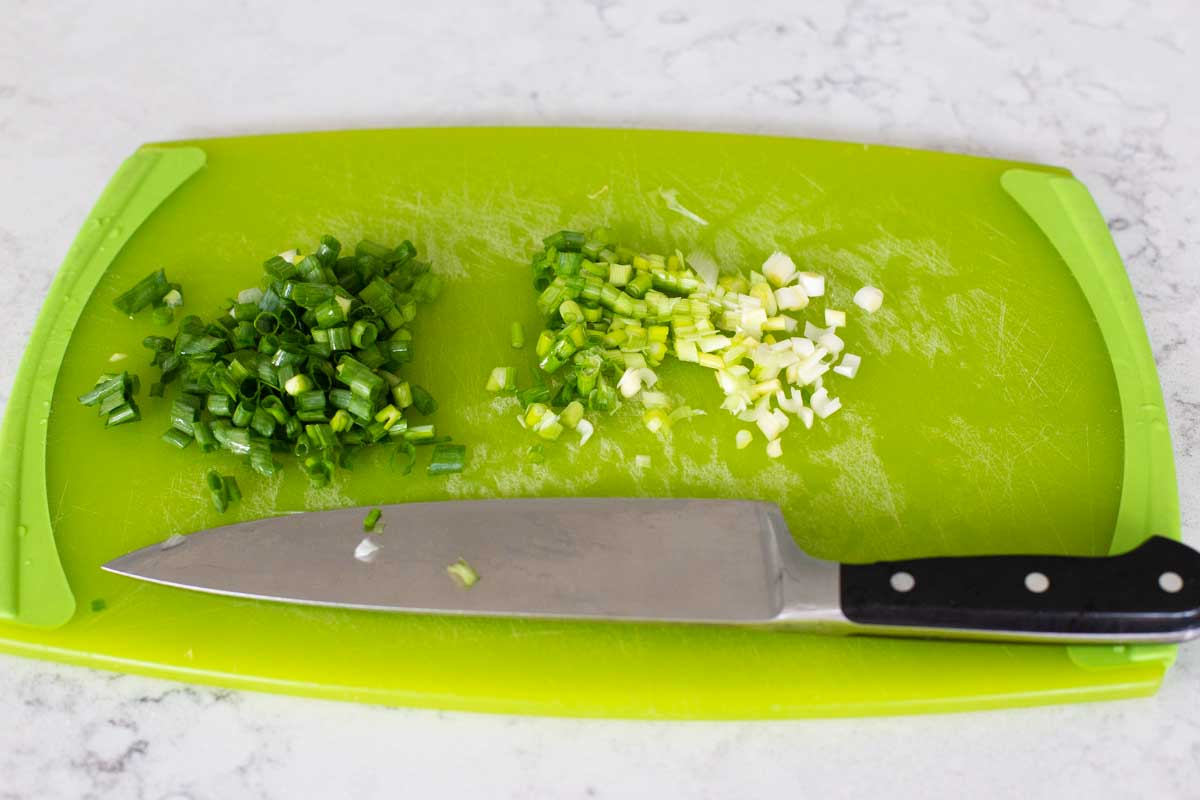 The green onions have been chopped and the whites and greens separated by a chef knife.