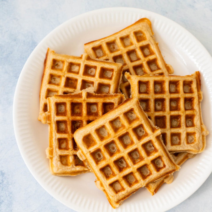 A white plate is filled with buttermilk waffles.