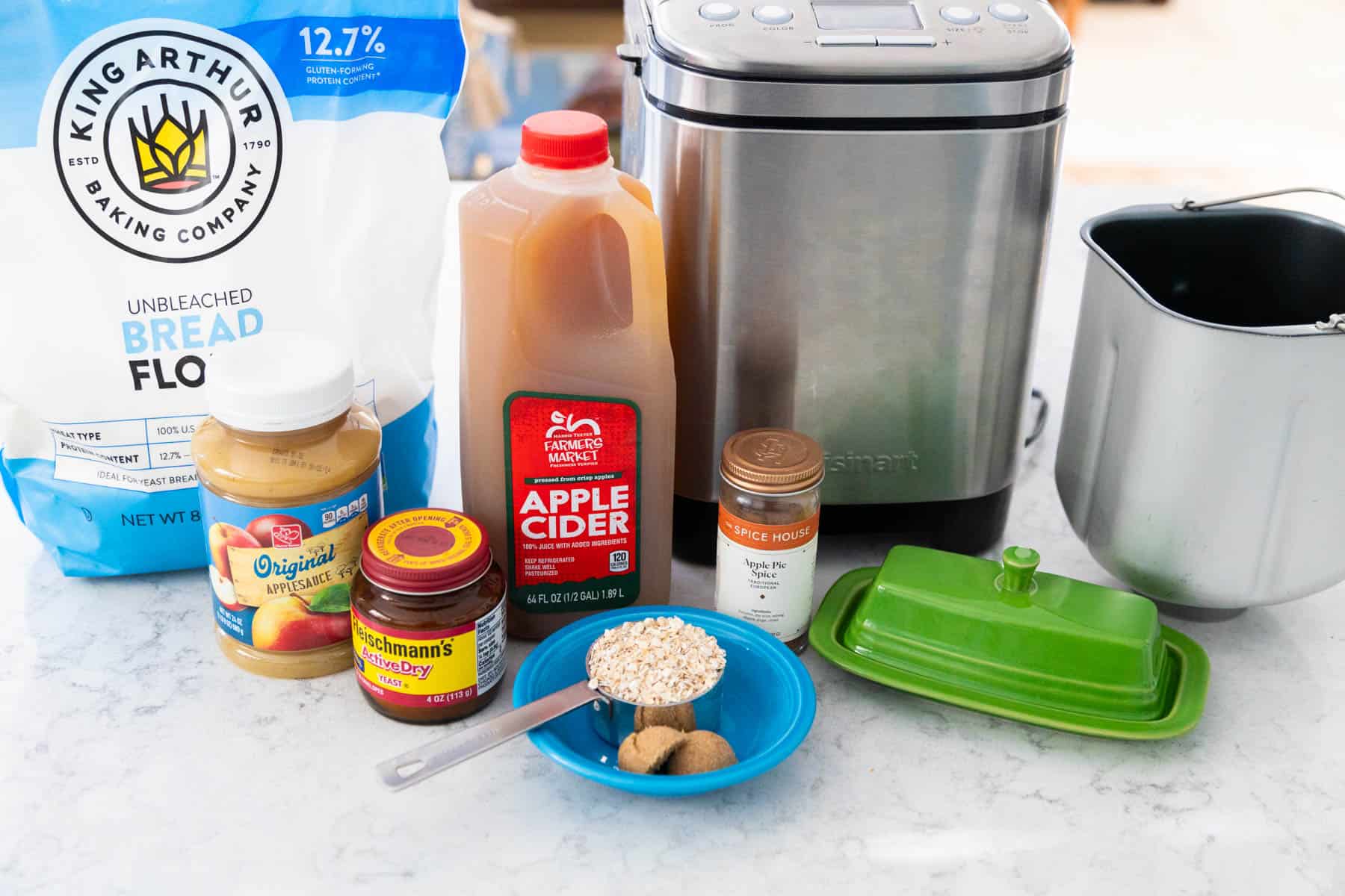 The ingredients to make an apple bread in a bread machine are on the counter.