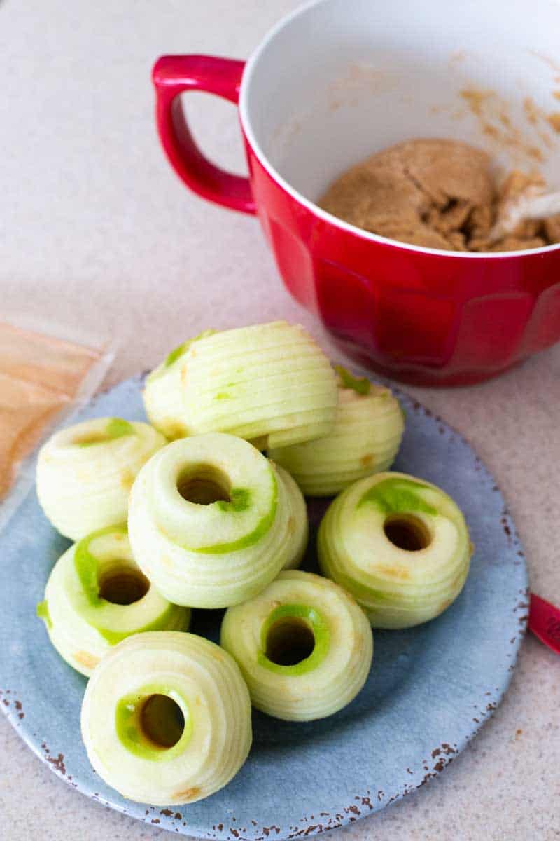 The apples have been run through the apple spiraler and are sitting on a blue plate.