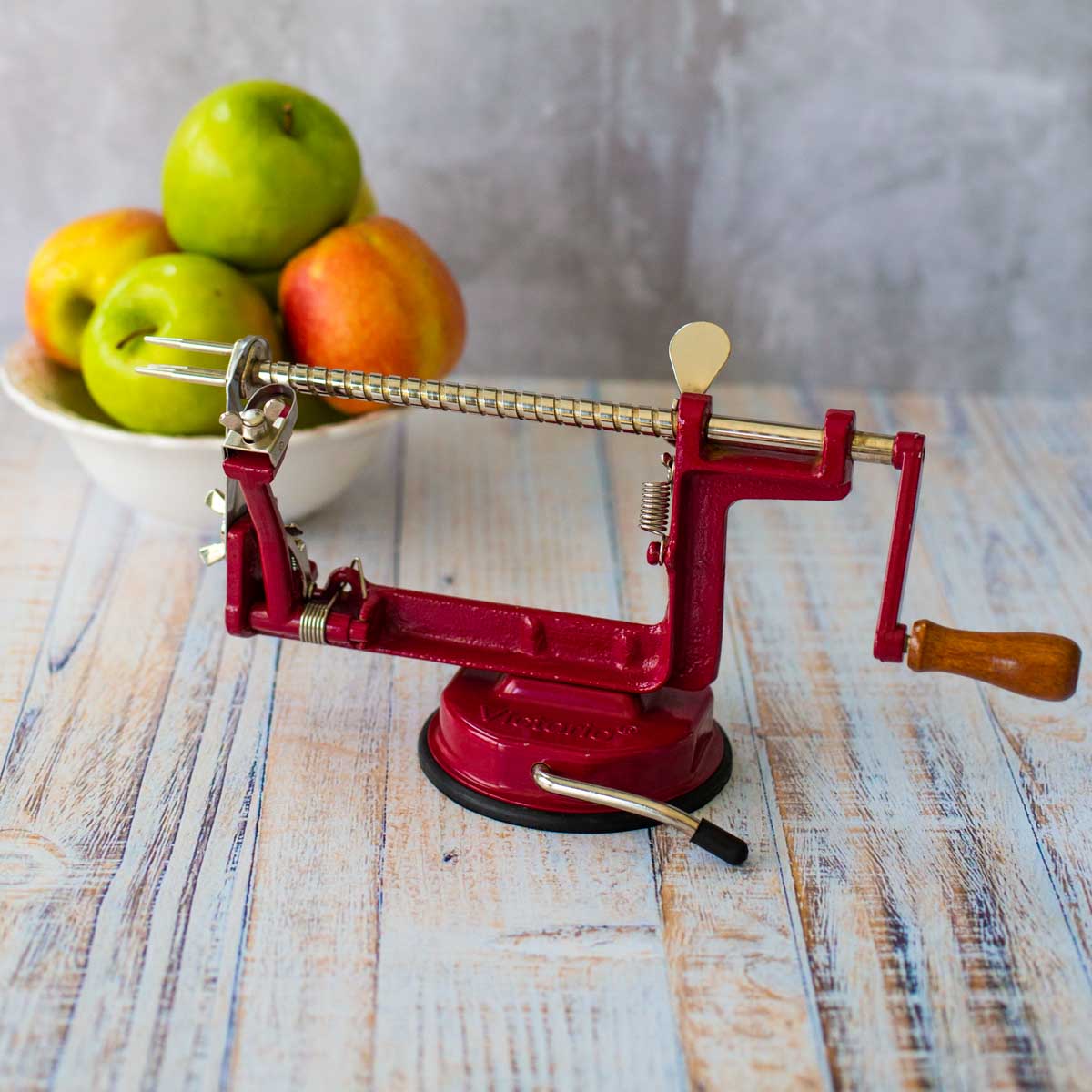 The red apple spiraler tool is shown next to a bowl of apples.