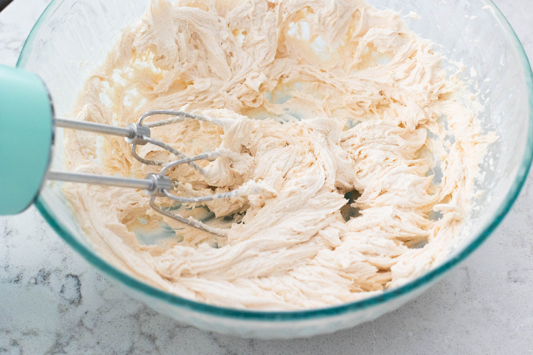 The hand mixer has beaten the frosting until light and fluffy.