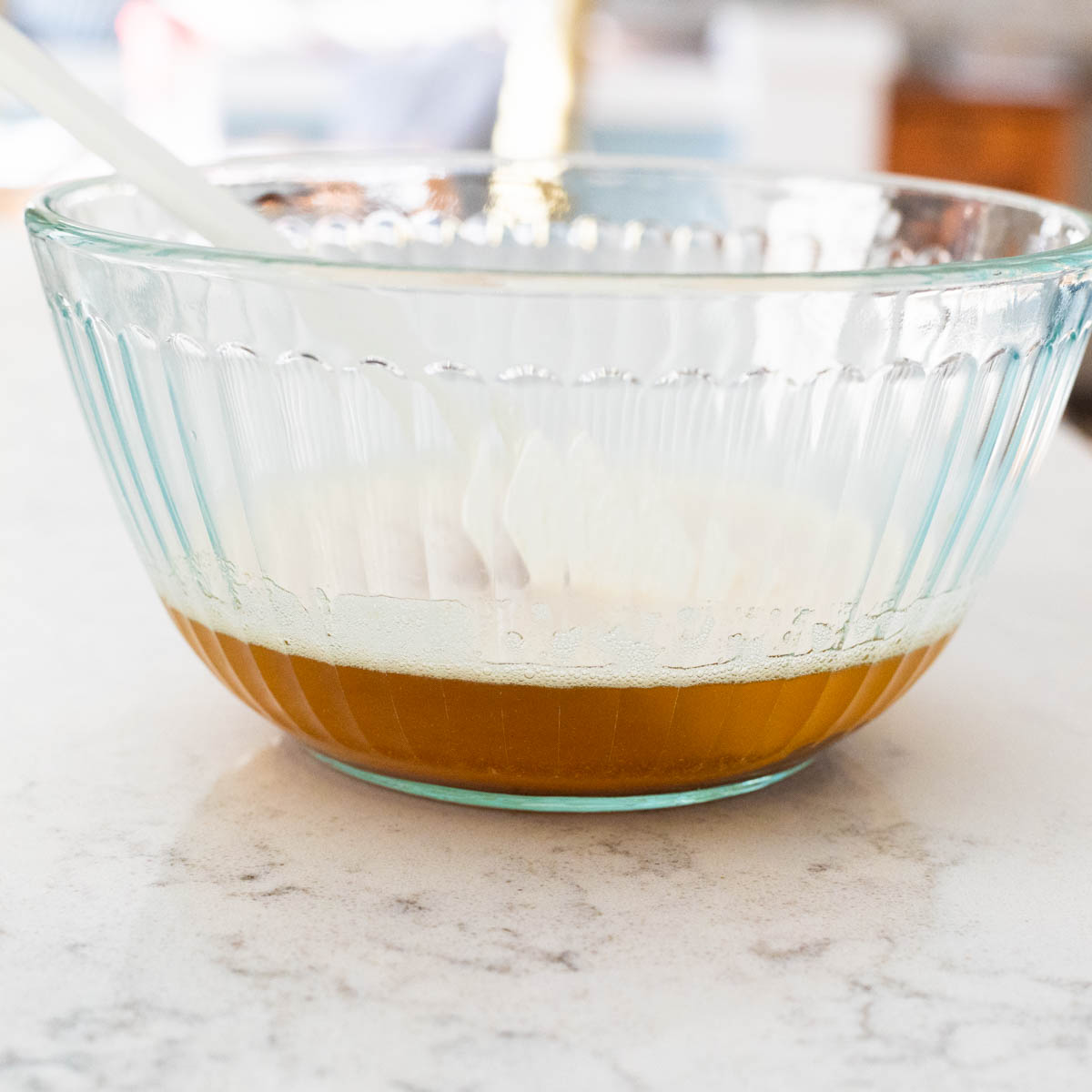The clear mixing bowl shows the dark brown color of the melted butter.
