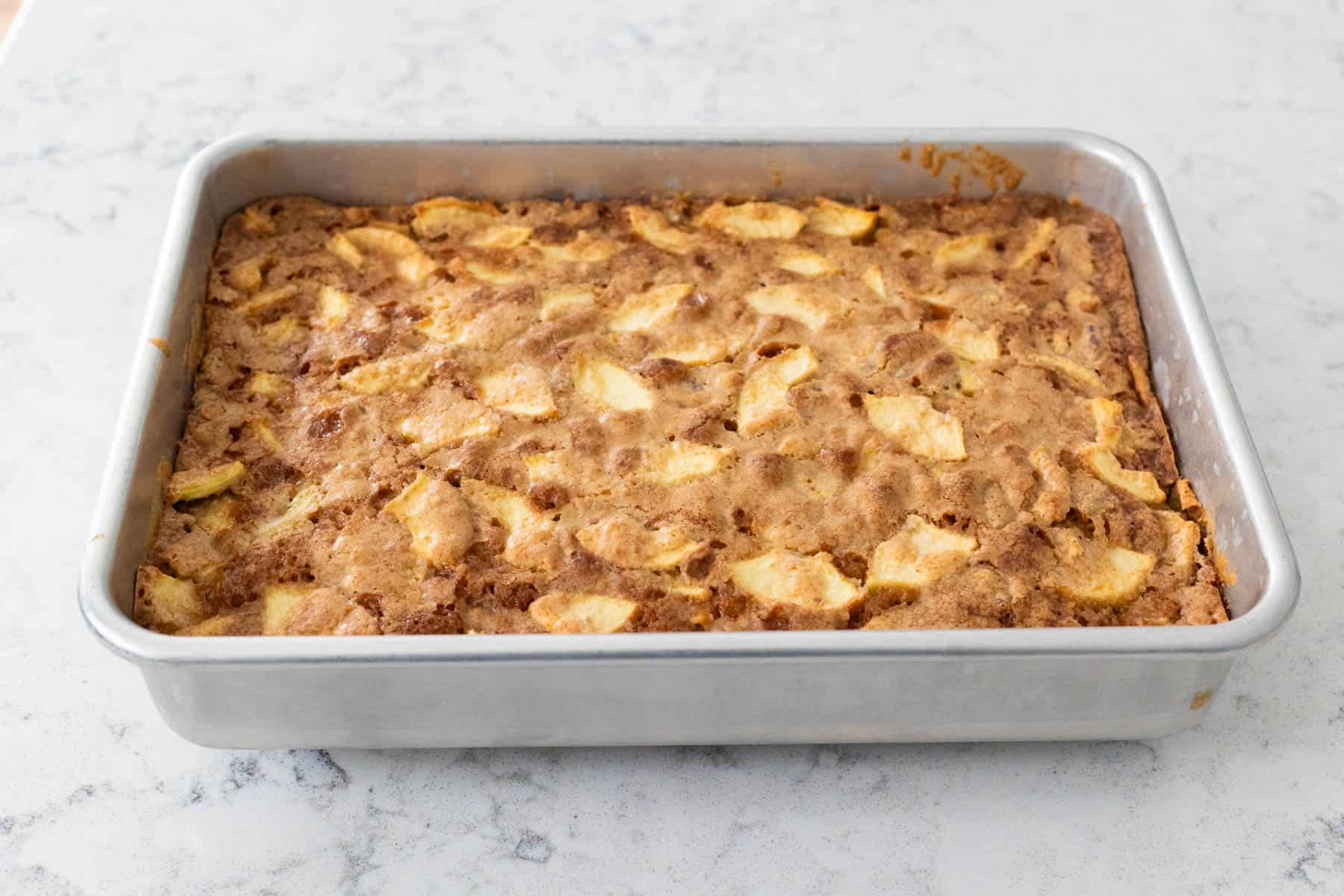 The apple cake is fresh from the oven and the top is golden brown.