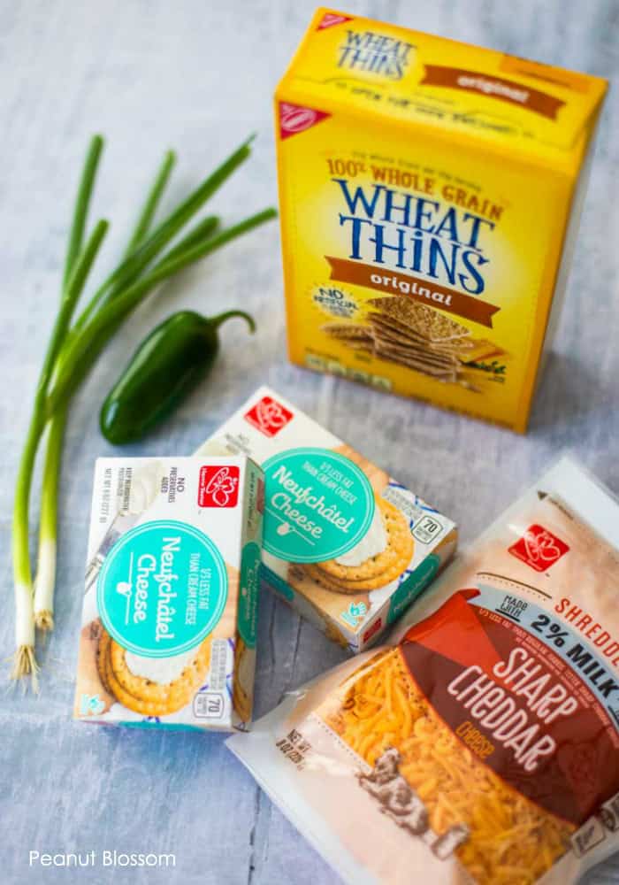 The easy jalapeno cheese ball requires just a few easy ingredients: Wheat Thins, 2 green onions, a jalapeno pepper, 2 packages of Neufchatel Cheese, and some shredded sharp cheddar.