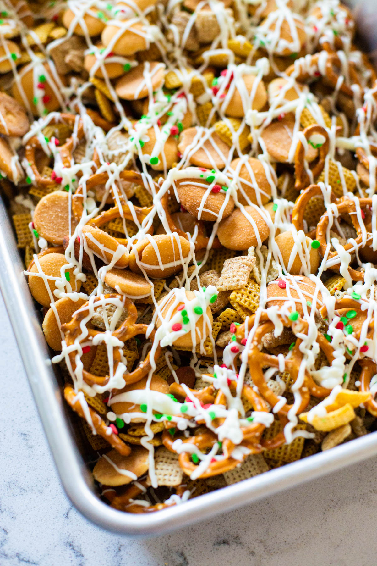 The chex mix has drizzled white chocolate over the top.