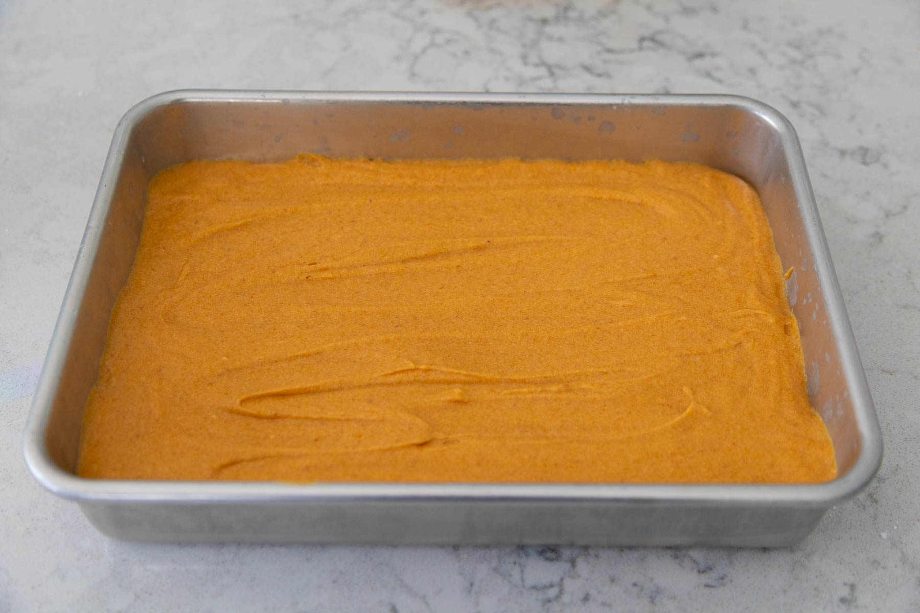 The pumpkin filling has been spread over the cake crust.