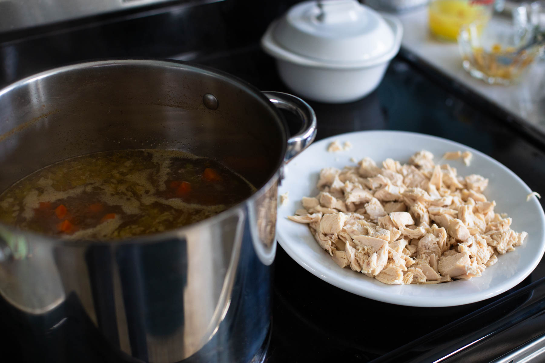 The plate of chopped chicken sits next to the pot of soup.