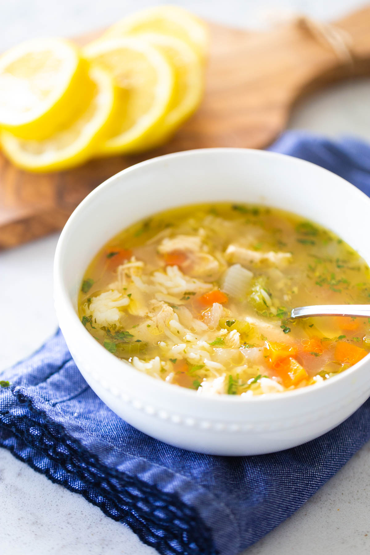 The white bowl is filled with classic chicken soup.