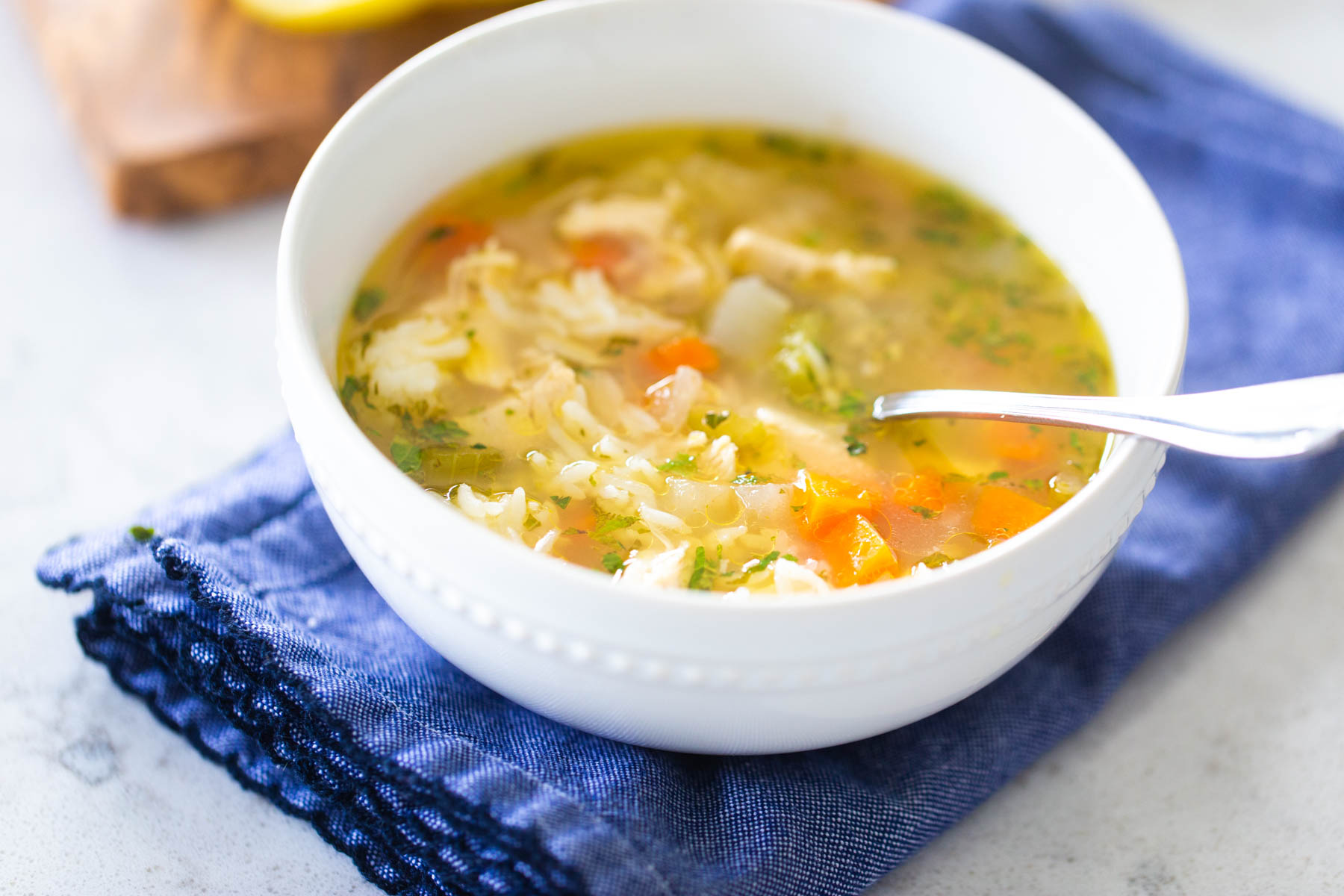 The white bowl is filled with classic chicken soup.