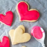 How to host a cookie decorating party for Valentine's Day. Sugar cookies with pink icing and a spoon.
